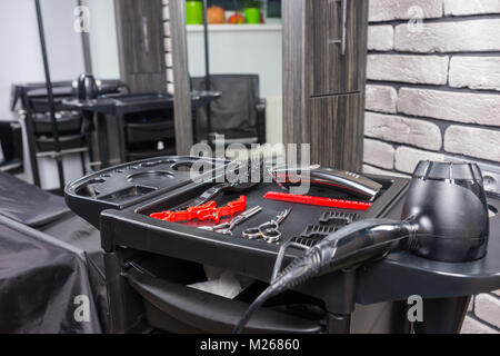 Friseur Werkzeuge und Haartrockner auf einem speziellen Stand im Beauty Salon Stockfoto