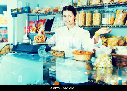 Freundlich lächelnde Frau Verkauf von Cookies und anderen Füllungen Stockfoto