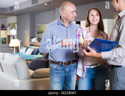 Lächelnd Verkäufer in Möbelhaus Kunden zeigen Produkt Katalog Stockfoto