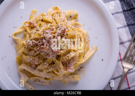 Nahaufnahme der Pasta Carbonara, auf eine weiße Platte mit einem dunklen Hintergrund Stockfoto