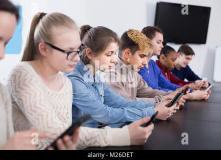 Positive Deutschland Mitschüler über ihre Smartphones intensiv während der Klassen Stockfoto