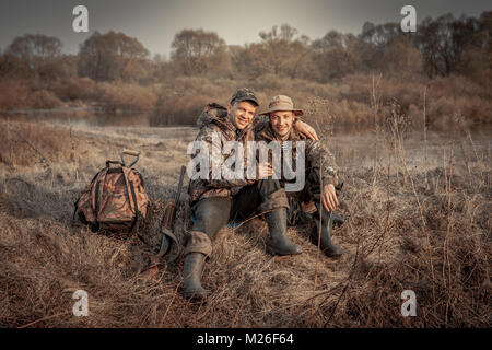 Hunter Männer Freunde ruht im ländlichen Bereich bei der Jagd Zeitraum starke Freundschaft symbolisieren. Stockfoto