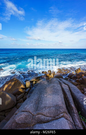 Großen Granitfelsen, Palmen und blaues Wasser auf einem rauen Küste des Ozeans, Anse Bazarca, Seychellen Stockfoto