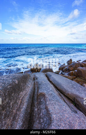 Großen Granitfelsen, Palmen und blaues Wasser auf einem rauen Küste des Ozeans, Anse Bazarca, Seychellen Stockfoto