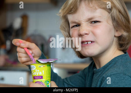 Junge, 7 Jahre alt, schmeckt veganes Essen, Soja Frucht Joghurt ersetzen, Stockfoto