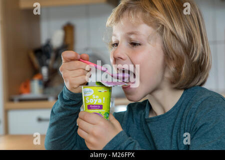 Junge, 7 Jahre alt, schmeckt veganes Essen, Soja Frucht Joghurt ersetzen, Stockfoto