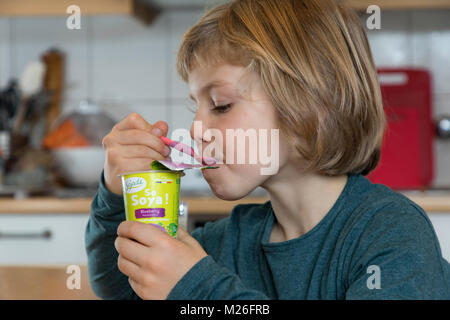 Junge, 7 Jahre alt, schmeckt veganes Essen, Soja Frucht Joghurt ersetzen, Stockfoto