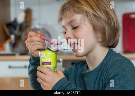 Junge, 7 Jahre alt, schmeckt veganes Essen, Soja Frucht Joghurt ersetzen, Stockfoto