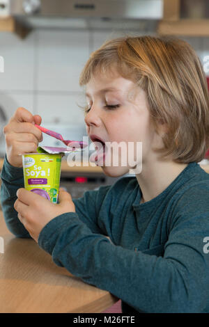 Junge, 7 Jahre alt, schmeckt veganes Essen, Soja Frucht Joghurt ersetzen, Stockfoto