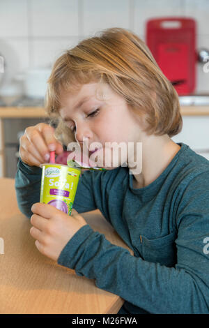 Junge, 7 Jahre alt, schmeckt veganes Essen, Soja Frucht Joghurt ersetzen, Stockfoto