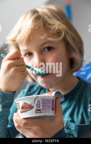 Junge, 7 Jahre alt, schmeckt veganes Essen, Soja Schokoladenpudding, ersetzen, Stockfoto