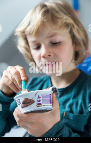 Junge, 7 Jahre alt, schmeckt veganes Essen, Soja Schokoladenpudding, ersetzen, Stockfoto