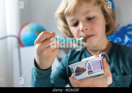 Junge, 7 Jahre alt, schmeckt veganes Essen, Soja Schokoladenpudding, ersetzen, Stockfoto