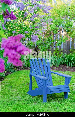 Adirondack Stuhl in einem Garten im Hinterhof. Stockfoto