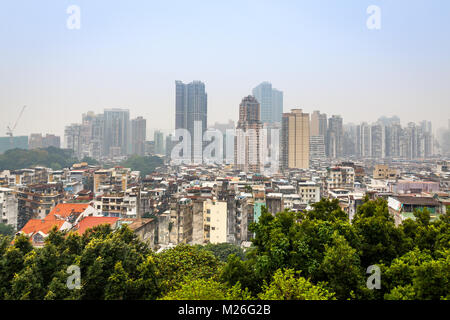 Macau Innenstadt Panorama mit Slums und hohen Wohn Gebäuden mit Bäumen im Vordergrund, China Stockfoto