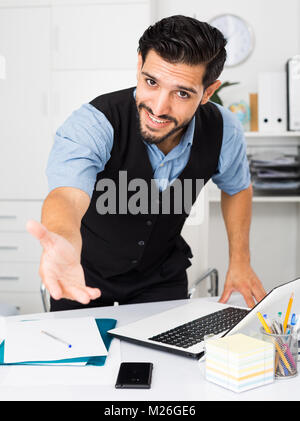 Spanischer mann Manager wird die ersten Besucher in seinem Büro zu treffen. Stockfoto