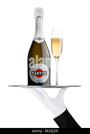 LONDON, Großbritannien - 24 November, 2017: Hand mit Handschuh hält Tablett mit Martini Asti Champagner Flasche und Glas auf weißem Hintergrund. In Italien produziert Stockfoto