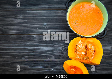 Kürbissuppe auf schwarzem Holz- Hintergrund Stockfoto