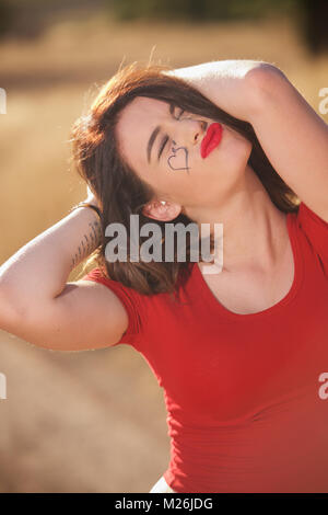 Schöne brünette Mädchen - Kopf und Schultern trägt ein rotes T-Shirt und auf dem Land. Stockfoto