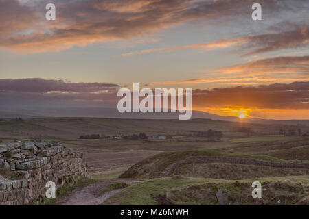 Hadrian's Wall: Ein Winter Blick nach Westen, auf der Suche über Sycamore Gap (zwischen Highshield und Peel Crags) bei Sonnenuntergang, mit kalten fiel in der Ferne Stockfoto