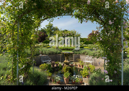 Eine versunkene Brunnen und Rosa" Cecile Brunner' auf einen Bogen in der Rose parterre Houghton Hall in King's Lynn, Norfolk, Großbritannien Stockfoto