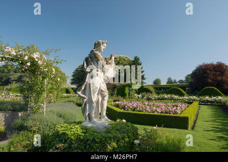 Eine steinerne Statue eines Lautenspieler von Betten von Rosen umgeben in der Rose parterre Houghton Hall, King's Lynn, Norfolk, Großbritannien Stockfoto