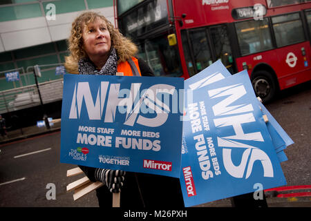 Demonstration von der Volksversammlung zur Unterstützung des NHS genannt. Hält eine Frau erhobenen Plakaten mit der Aufschrift 'NHS mehr Personal, mehr Betten, mehr Mittel". Stockfoto