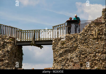 Ein paar Blick auf eine Infotafel an den Wänden von Framlingham Schloss Stockfoto