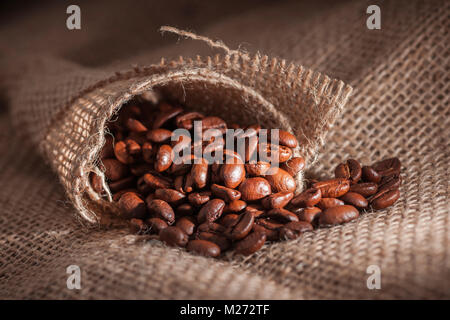 In der Nähe von gerösteten Kaffeebohnen liegen auf grobem Jutegewebe in Low Angle View in der schmalen Seite Licht. Stockfoto