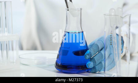 Chemielehrer, Trockeneis in blaue Flüssigkeit in Erlenmeyerkolben, close-up Stockfoto