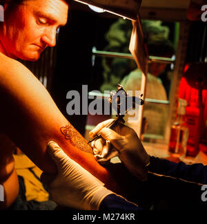 Tattoo Künstler Marc Saint Tätowieren ein keltisches Design auf einem Kunden arm, London, Tätowierer, Archiv Foto 1990