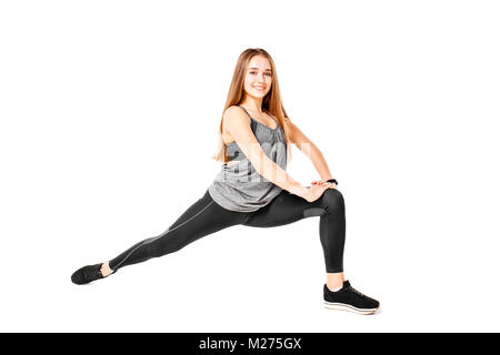 Junge Mädchen tun Fit Pilates Übungen auf weißem Hintergrund. Schlanke Mädchen stretching auf dem Boden Stockfoto