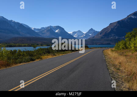 Hübsche malerische Landschaft Ansicht von der Straße des Glacier National Park mit Schnee Berggipfel in der Ferne und River, Montana, USA Stockfoto