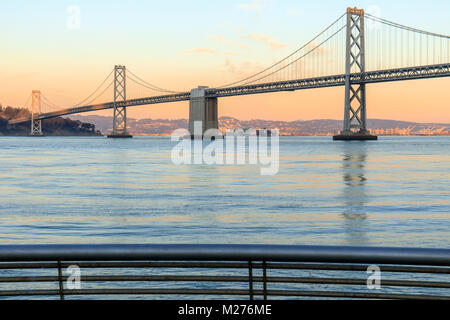 San Francisco Bay Bridge und Pier 14 Schienen bei Sonnenuntergang. Stockfoto