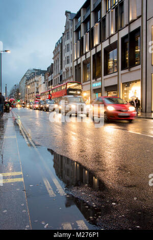 Nasse Straßen von Oxford Street glitzern in der Straßenbeleuchtung Stockfoto