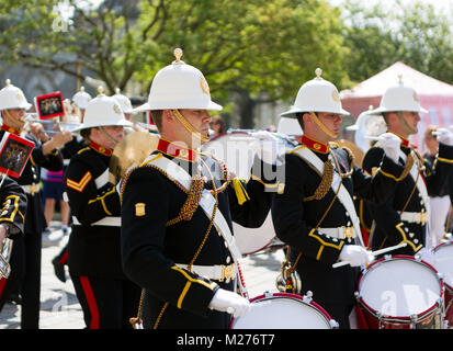 The Band Of HM Royal Marines Marsch durch's Plymouth Royal William Yard auf einem hellen, sonnigen Tag. Stockfoto