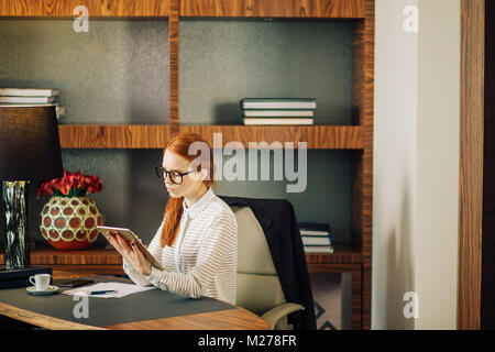 Geschäftsfrau Brille mit digitalen Tablette im Büro Stockfoto