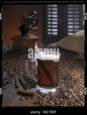 Dampfend heißer Kaffee im Glas Schale mit Zimtstange. Stockfoto