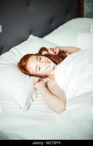 Schlafende junge Frau liegt im Bett, mit geschlossenen Augen. top View Stockfoto