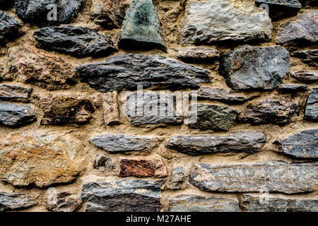 Wand aus Granit Stein Tapete, backgroung mit Steinen und Beton Stockfoto