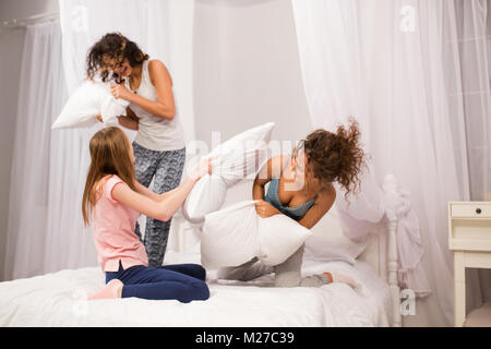 Mädchen im Bett mit Kissen kämpfen im Pyjama Stockfoto