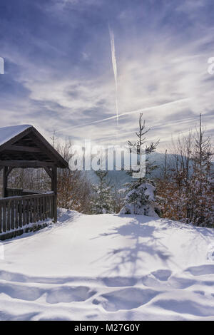 Gartenlaube aus Holz in der Nähe von Mountain Trail. Winter sonniger Tag und dunstige Berge im Hintergrund. Kremnica Berge, Slowakei, Europa. Stockfoto