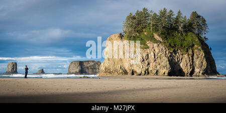 Ein Mann, der vor einem Meer stack am Strand des pazifischen Ozeans Stockfoto