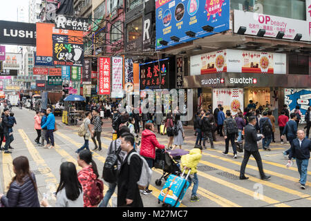 Hongkong - 25. Januar 2018: Überqueren einer viel befahrenen Straße in den sehr überfüllten Mong Kok Einkaufszentrum von Kowloon, Hong Kong Stockfoto