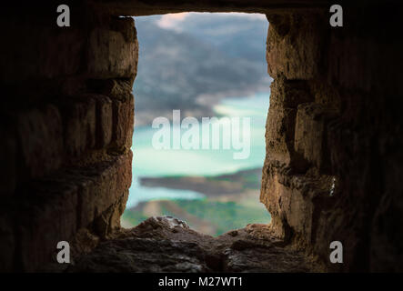 Luftaufnahmen des Flusses Guadalete und die Behälter durch einen kleinen Stein Fenster des Schlosses von Zahara de la Sierra. Foto mit Landschaft Blur, De Stockfoto