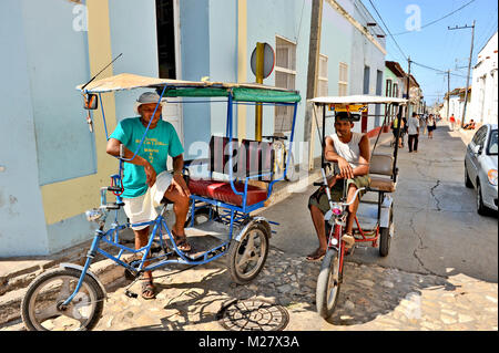 TRINIDAD, Kuba, 27. Oktober 2009. Zwei Rikschas und ihre Fahrer warten in der Straße in Trinidad, Kuba, am 27. Oktober 2009. Stockfoto