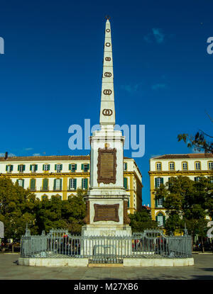 Blick auf das Denkmal Torrijos und Gebäuden. Riesige Obelisken in der Plaza de la Merced, das Geburtshaus von Picasso. Dezember 2017, Málaga, Spanien. Stockfoto