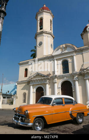 CIENFUEGOS, Kuba - Januar 3, 2017: Alte Autos in der Jose Marti Park, dem Hauptplatz von Cienfuegos geparkt, vor dem Purisima Concepcion Cathedr Stockfoto