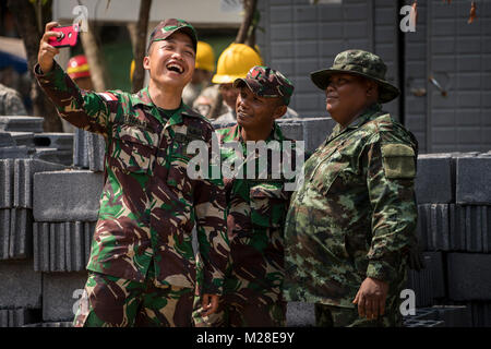 Indonesische Armee Soldaten nehmen ein selfie mit einer Royal Thai Army Soldat vor einer Säule Anhebung Zeremonie für ein Schulgebäude für die Unterstützung der Übung Cobra Gold 2018 Banthungsohongsa Schule in Chachoengsao, Königreich Thailand, 31.01.2018. Humanitäre civic Hilfe Projekte während der Übung die Unterstützung und humanitären Interessen des thailändischen Volkes durchgeführt. Cobra Gold 18 ist eine jährliche Übung im Königreich Thailand durchgeführt und läuft vom 13-23 Februar mit sieben voll teilnehmenden Nationen. (U.S. Marine Corps Stockfoto