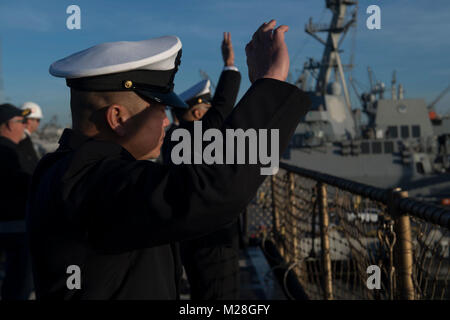 SAN DIEGO (Feb. 2, 2018) Master Chief Engineman Jose Valdes, der verantwortliche Befehl Master Chief der Amphibischen dock Landung Schiff USS Pearl Harbor (LSD 52), Wellen zu seiner Familie auf dem Schiff Flight Deck. Pearl Harbor, Teil der Amerika Amphibious Ready Group, mit 15 Marine Expeditionary Unit begonnen, ist die Rückkehr von einem 7-monatigen Einsatz in die USA 3., 5. und 7 Flotte Bereich der Operationen. (U.S. Marine Stockfoto